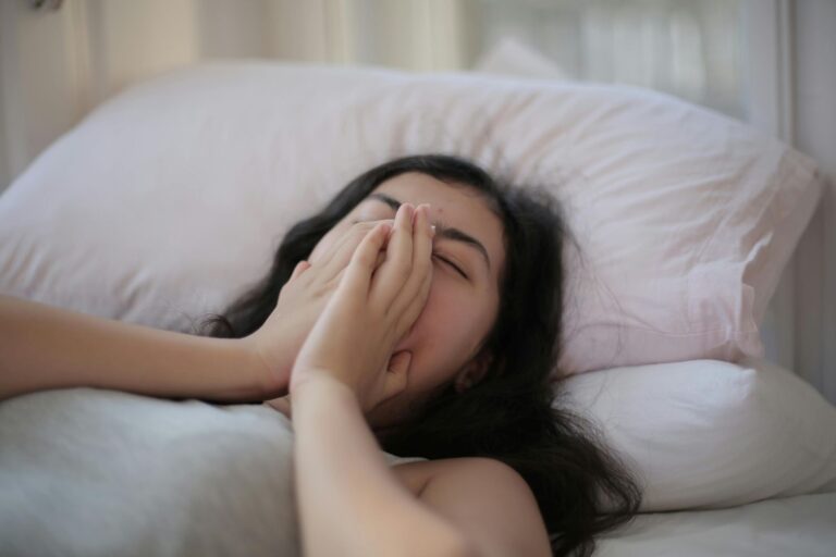 women lying on bed feeling tired and sleepy